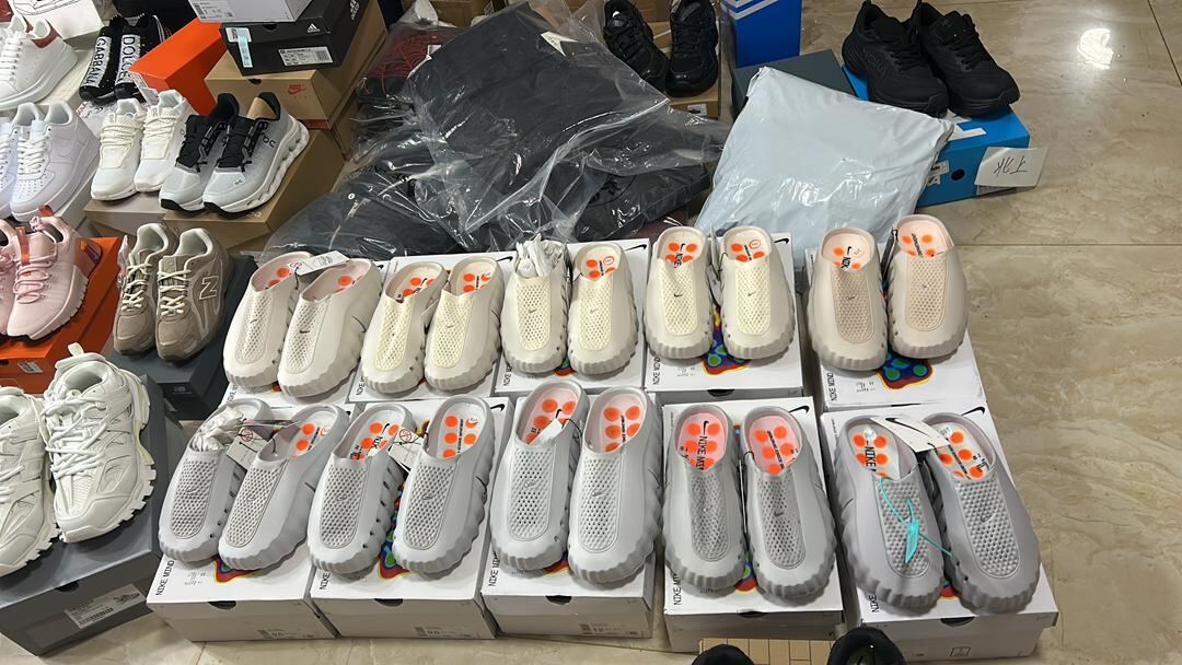 Nike Calm slippers collection in supplier warehouse — multiple colorways stacked